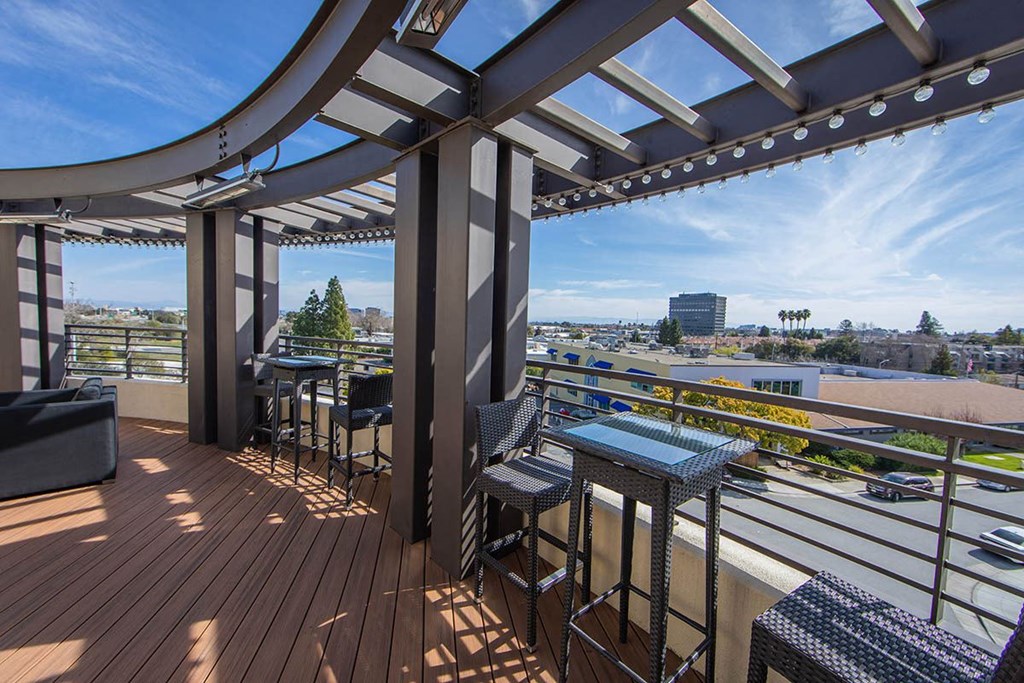 a balcony with tables and chairs and a view of the city