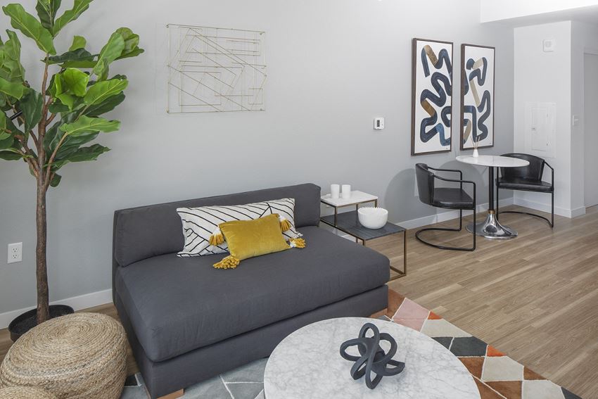 a living room with a gray couch and a table with chairs