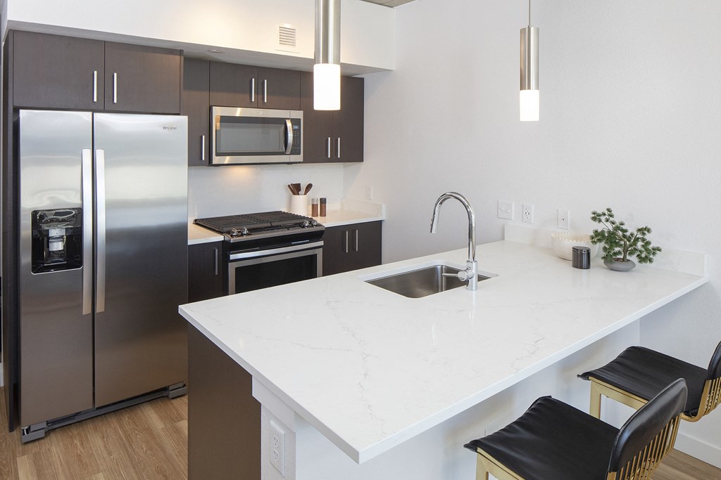 a modern kitchen with stainless steel appliances and a white counter top