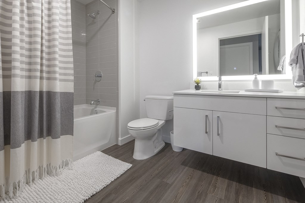 a white bathroom with a shower toilet and sink