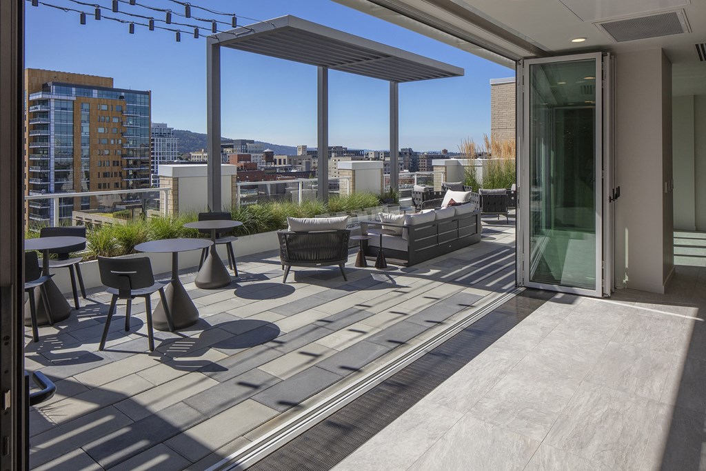 a terrace with tables and chairs and a glass door