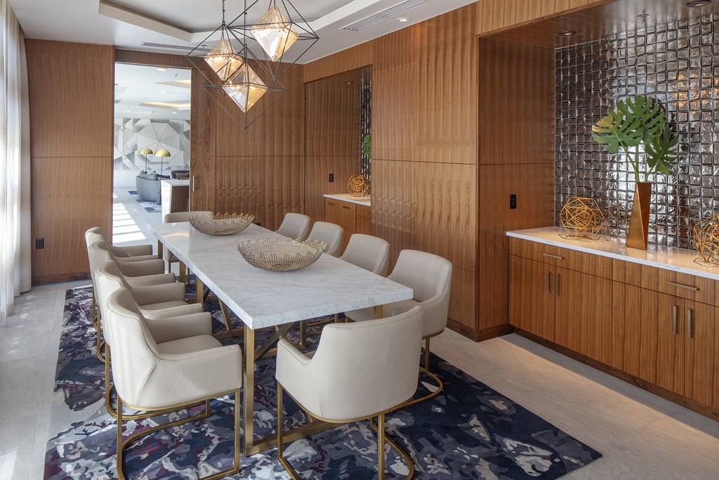 a dining room with a marble table and white chairs