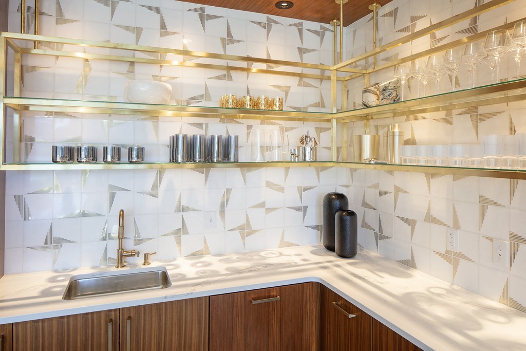 a kitchen with white tiles and glass shelves