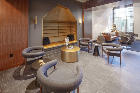 a lounge area with chairs and tables and a fireplace