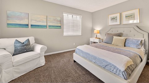 A bedroom with a large bed and a white couch.