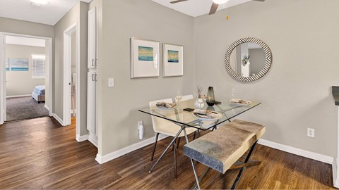 A dining room with a glass table and chairs.