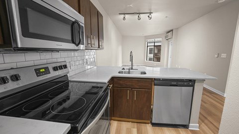 A modern kitchen with a stove top oven and microwave.