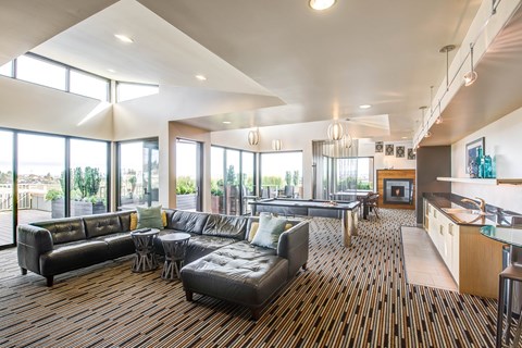 A modern living room with a fireplace and a kitchen area.