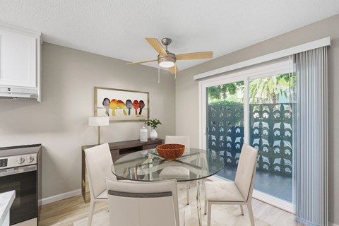 A modern kitchen with a glass table and chairs.