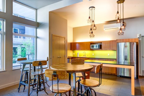A kitchen with a table and chairs in front of a window.