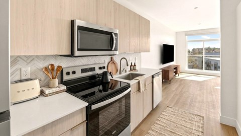 A modern kitchen with a white countertop and a black stove.