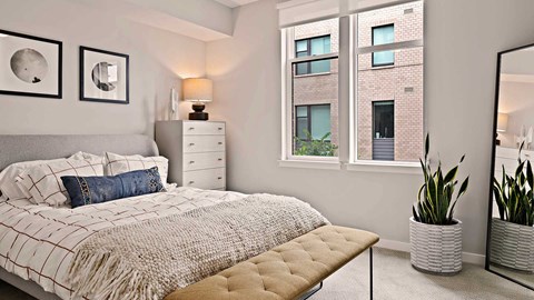 a bedroom with a bed and a large window