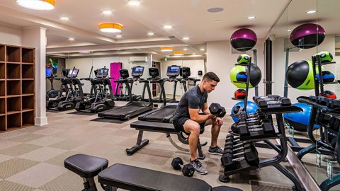 A man is working out in a gym with a variety of equipment.