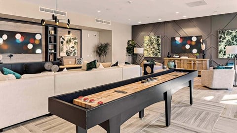 a games room with a shuffleboard table in a living room