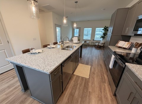 A kitchen with a granite countertop and wooden flooring.