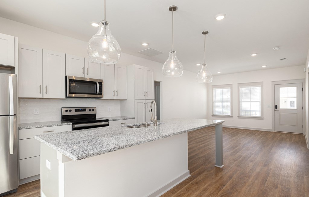 a kitchen with white cabinets and a marble counter top at Allier Port Wentworth Apartments, Port Wentworth