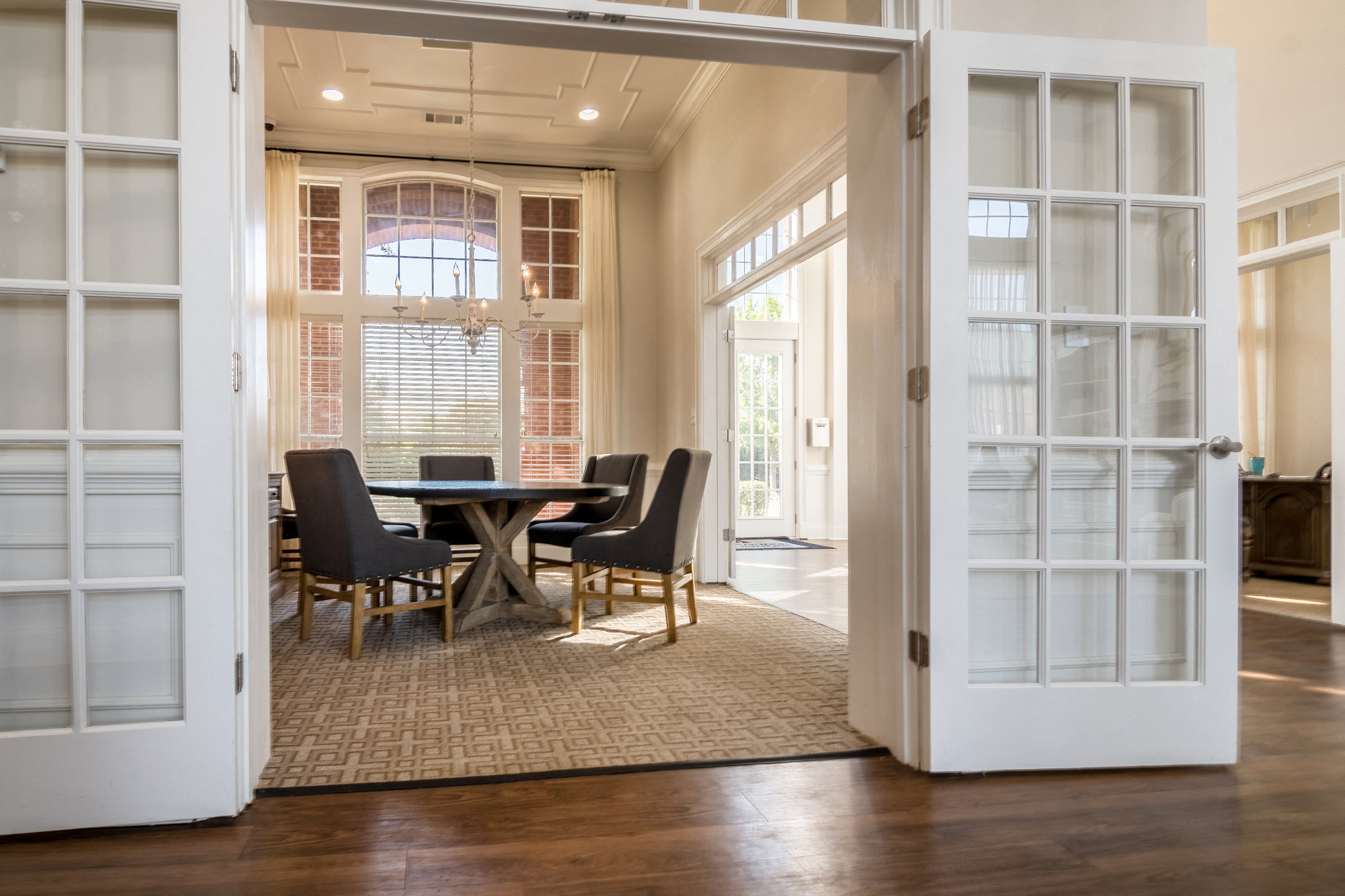 a dining room with a table and chairs in a room with open doors
