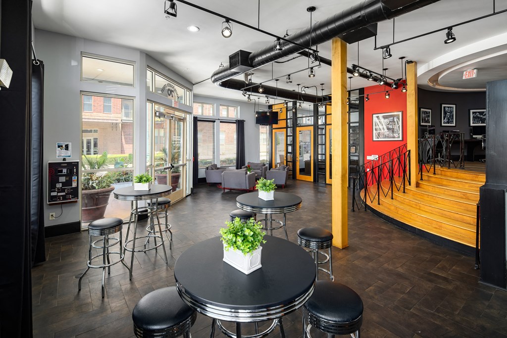 a large room with tables and chairs and a lobby with windows