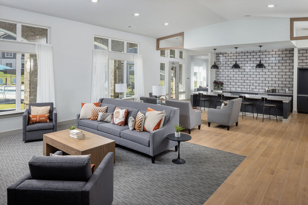 a living room with couches and chairs and a kitchen