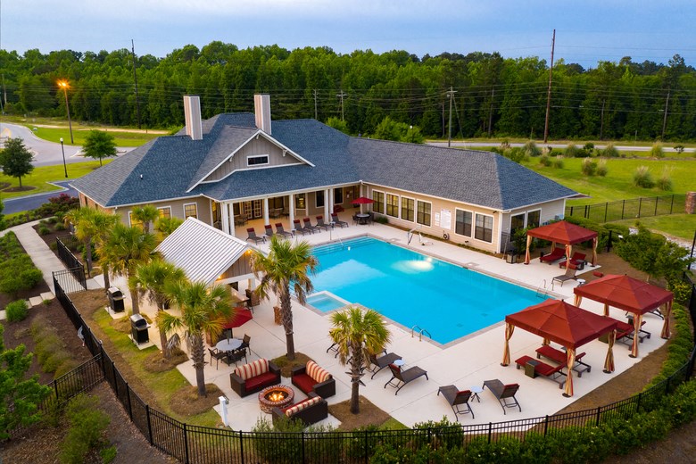 arial view of a swimming pool in front of a house