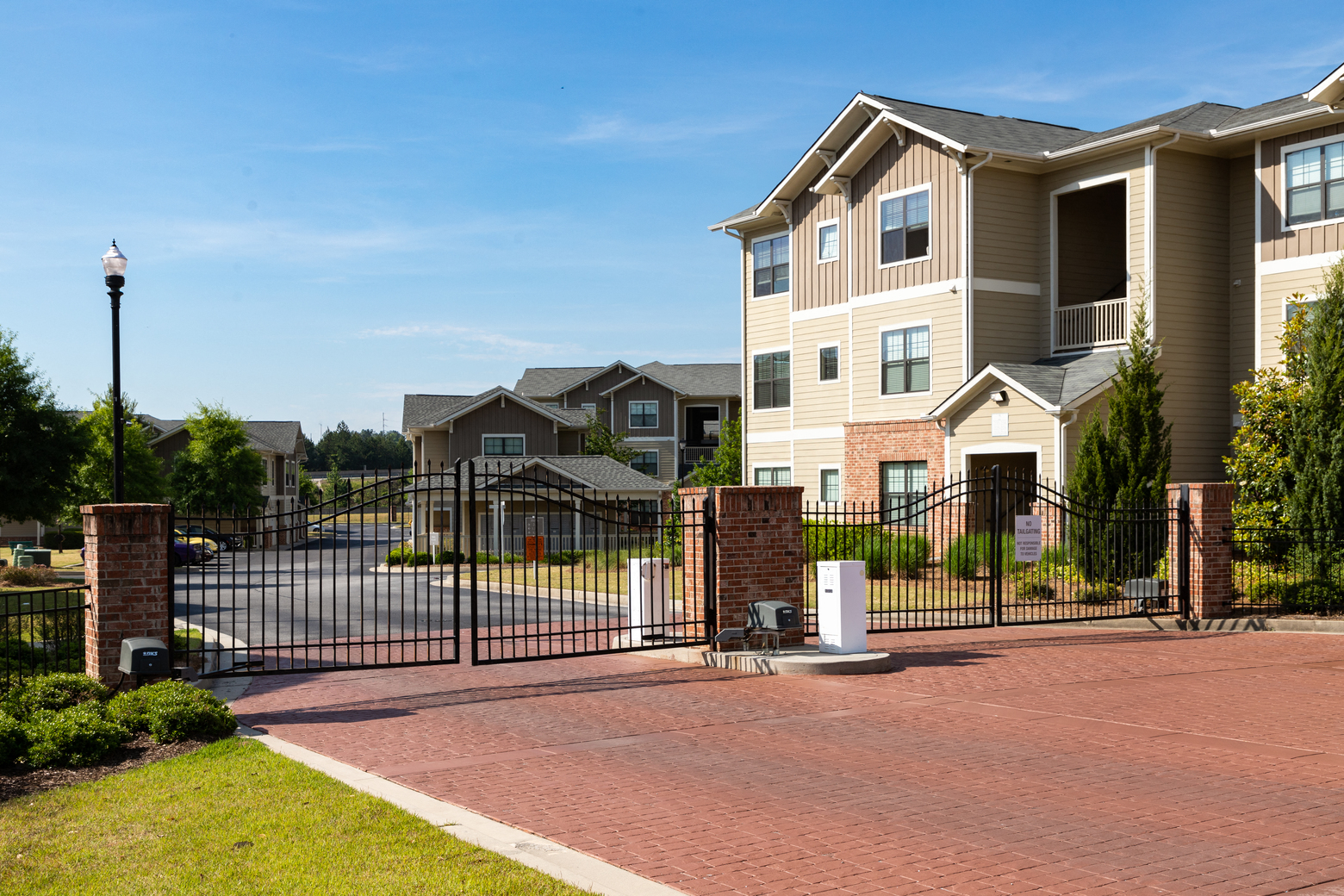 an apartment building with a driveway and a gate