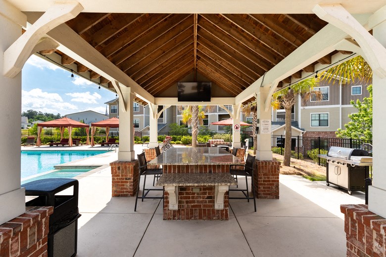the preserve at ballantyne commons covered patio with table and chairs and a pool