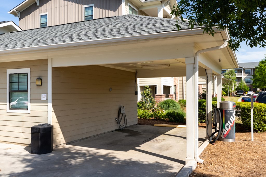 a covered porch with a garbage can in front of a house