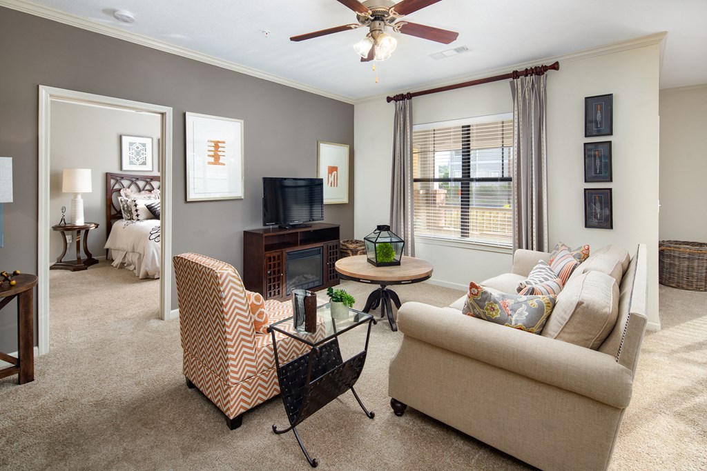 a living room with a couch and a table and a ceiling fan