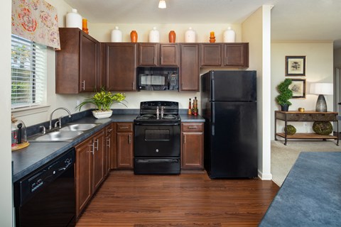 a kitchen with black appliances and dark wood cabinets