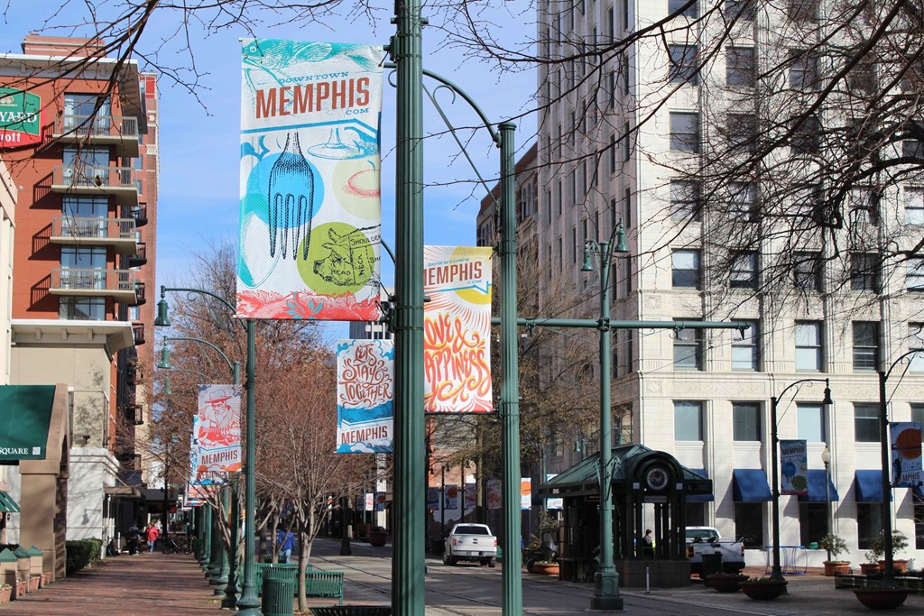 a city street with tall buildings and signs on the poles