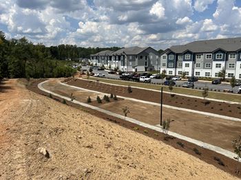 A construction site with a few trees and a building in the background. at Fairview Springs in Covington, GA, 30016