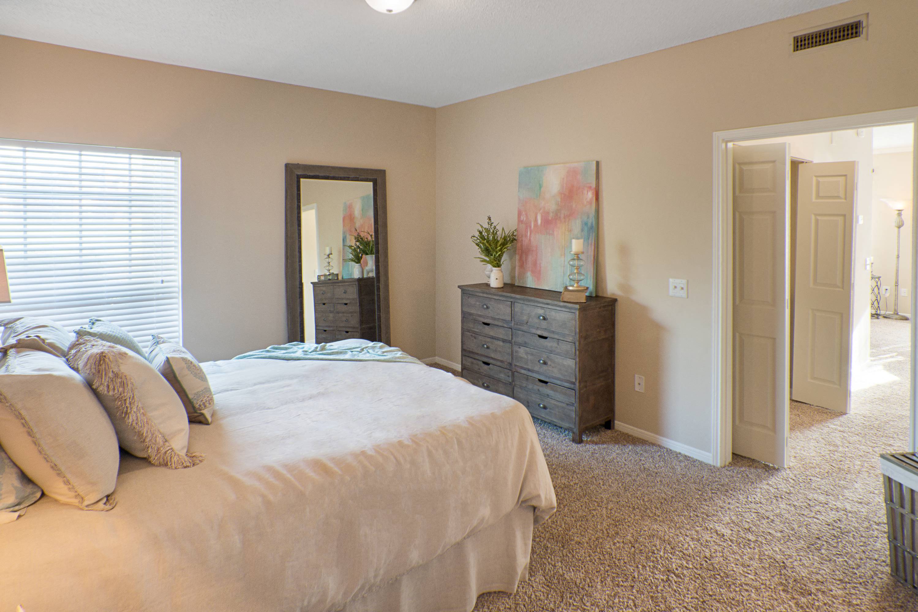 a bedroom with a bed and a dresser and a window