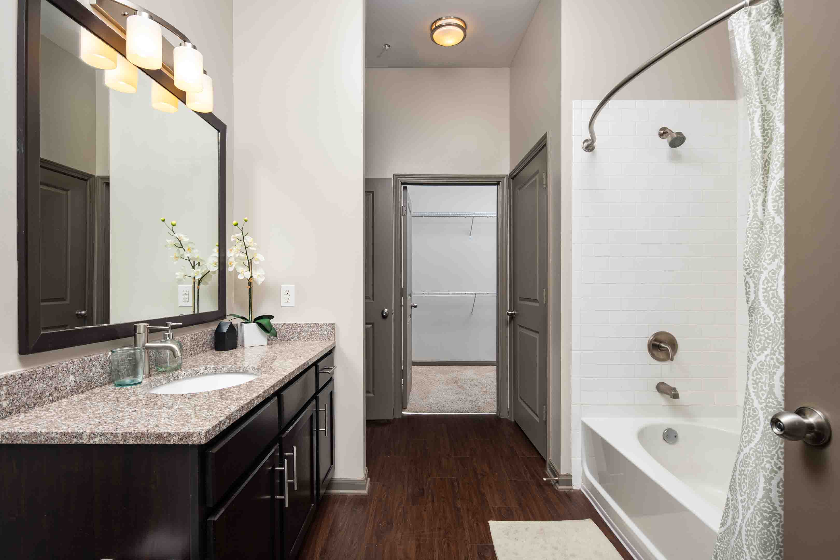 a bathroom with a shower and a sink and a mirror