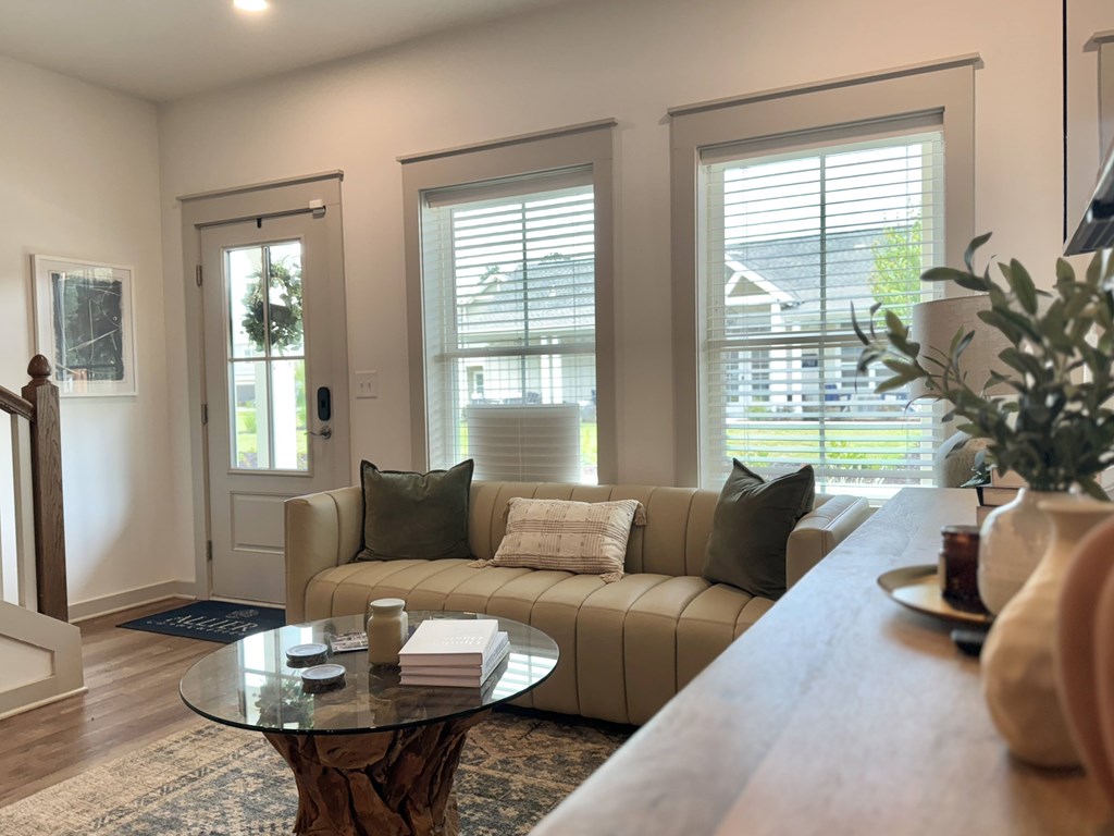 A living room with a couch, coffee table, and a plant at Allier Foley, Foley