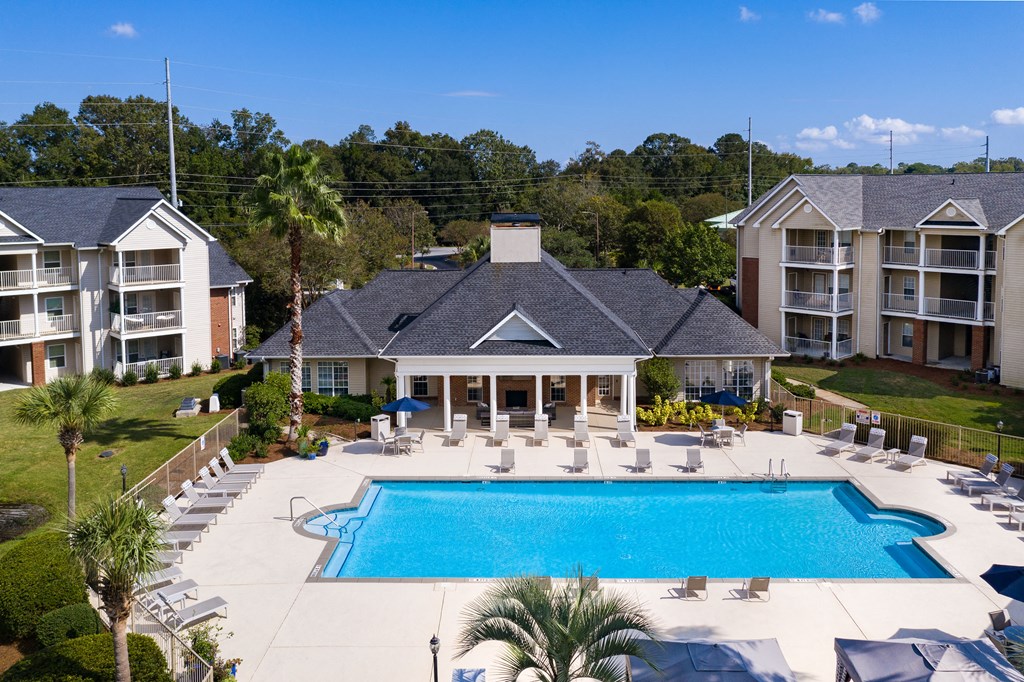 an aerial view of a swimming pool in front of a large house with a pool