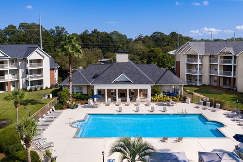 an aerial view of a swimming pool in front of a large house with a pool