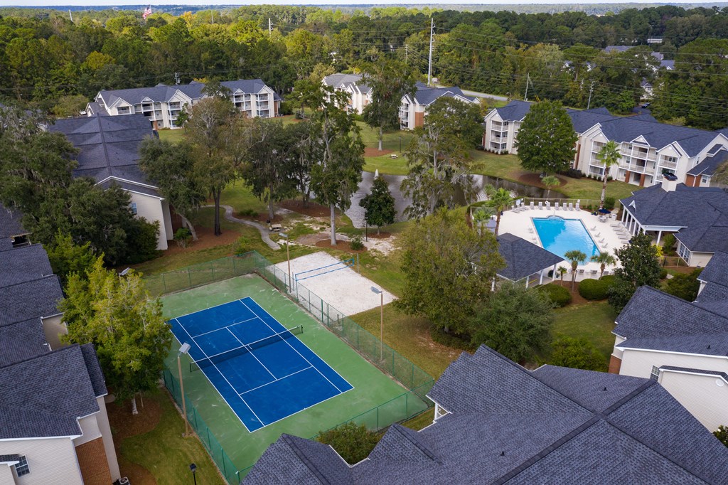 an aerial view of a tennis court in a neighborhood with houses
