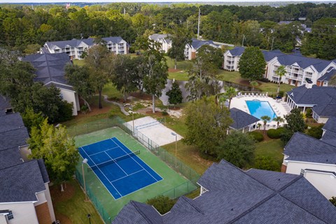 an aerial view of a tennis court in a neighborhood with houses
