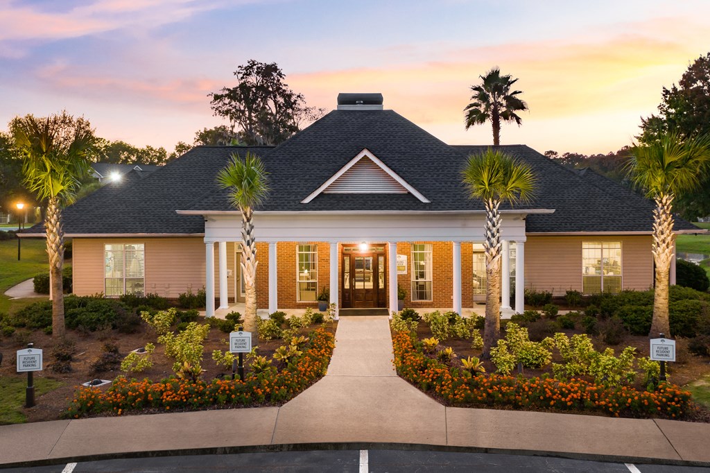 the front of a house with palm trees in front of it