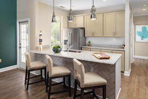 a kitchen with a large island with three chairs in front of it