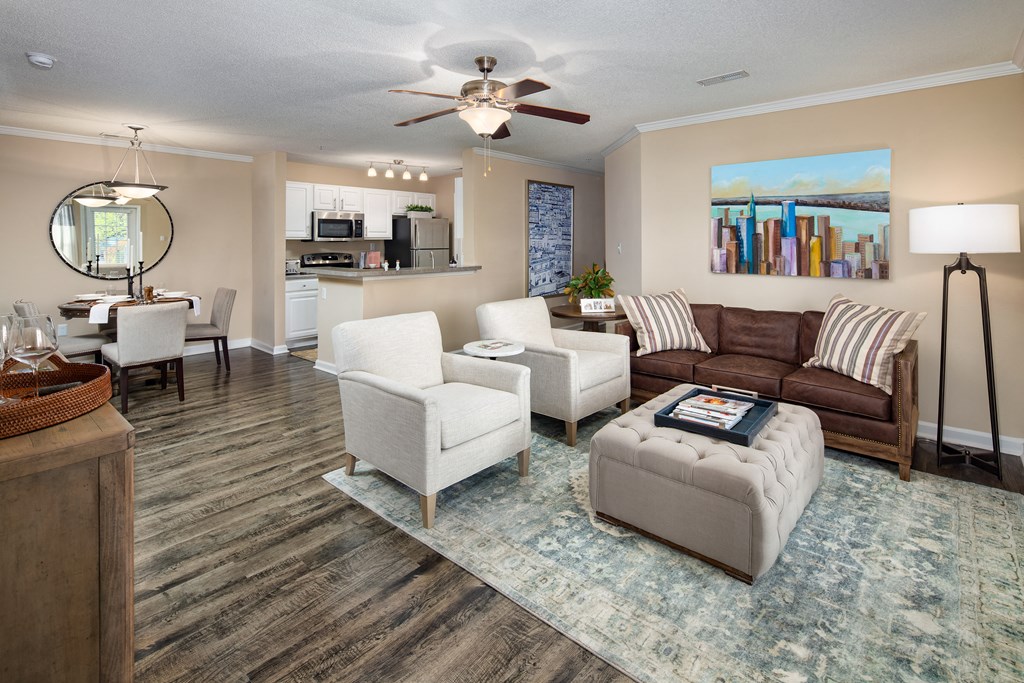 a living room with a couch and chairs and a ceiling fan