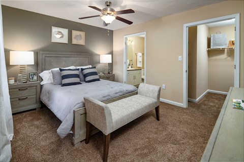 a bedroom with a bed and a chair and a ceiling fan