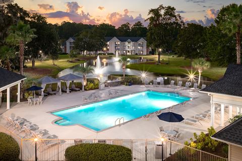 an aerial view of a resort pool at dusk
