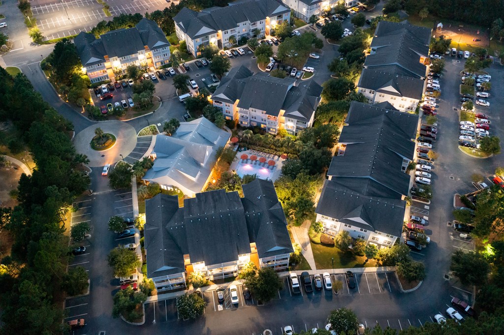 an aerial view of a neighborhood at night with cars in a parking lot
