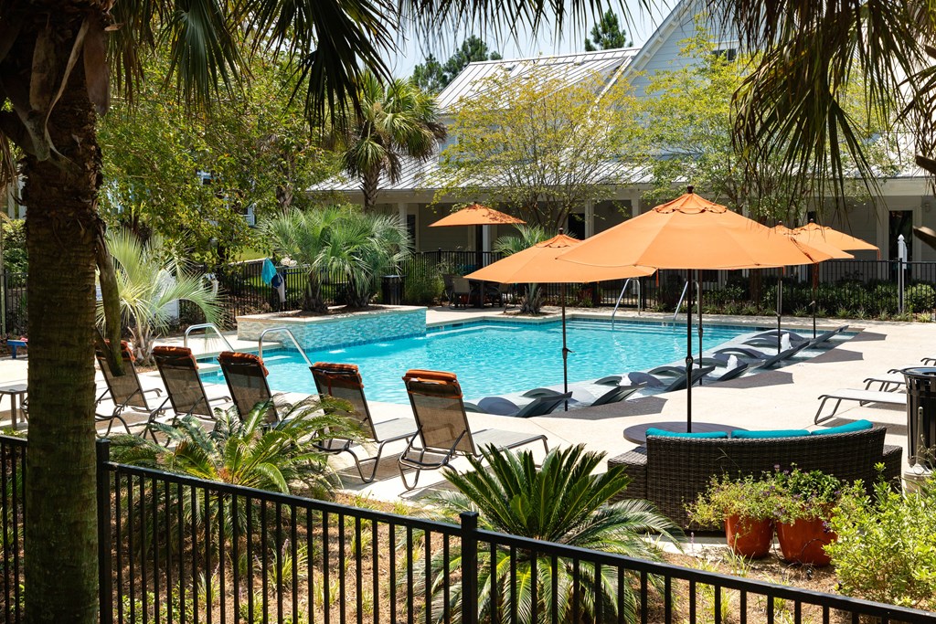 a swimming pool with chairs and umbrellas