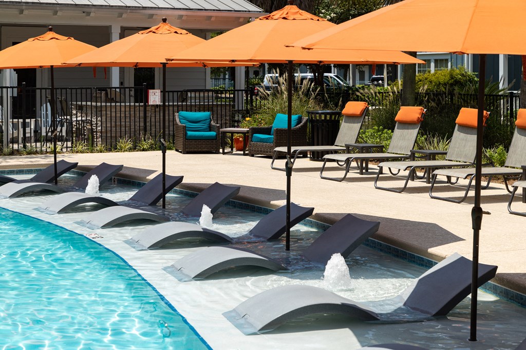 a swimming pool with chairs and umbrellas next to a hotel pool