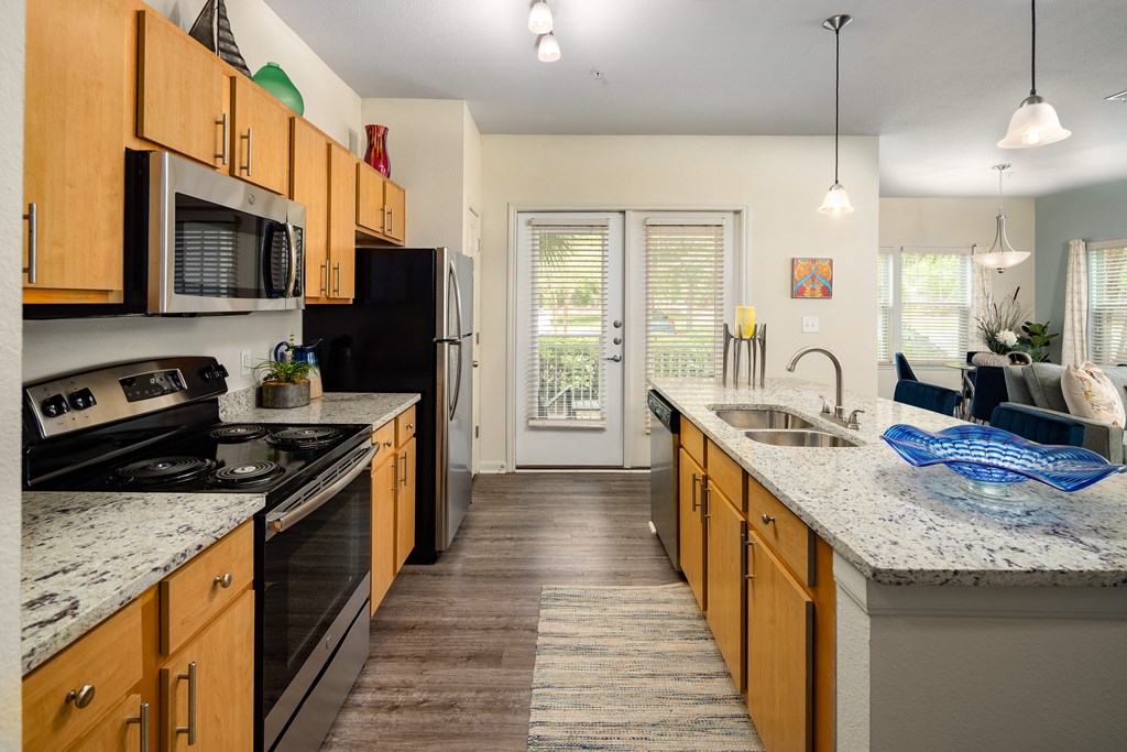 full kitchen with granite countertops and stainless steel appliances at the flats at west end