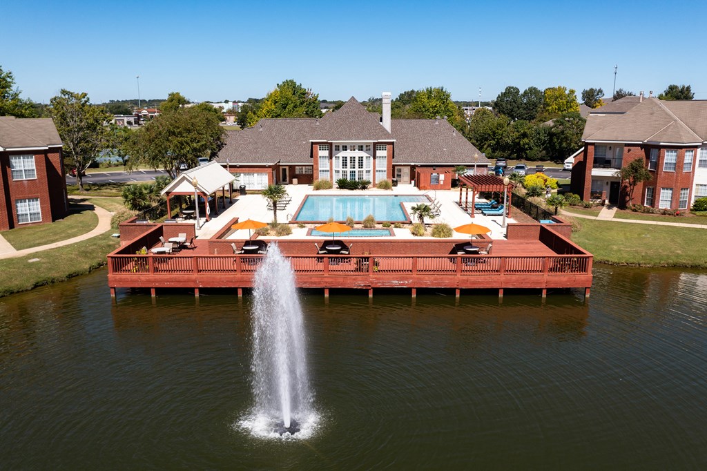 a large pool with a water fountain in front of a house
