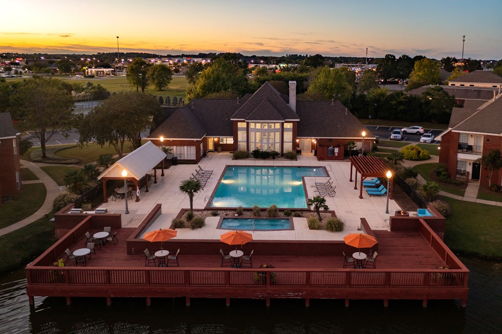 arial view of a swimming pool at night in front of a house