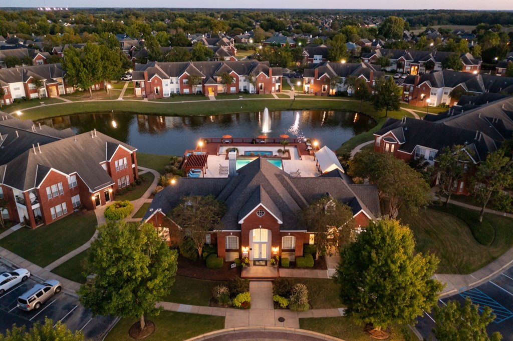 an aerial view of a neighborhood with a pond and houses
